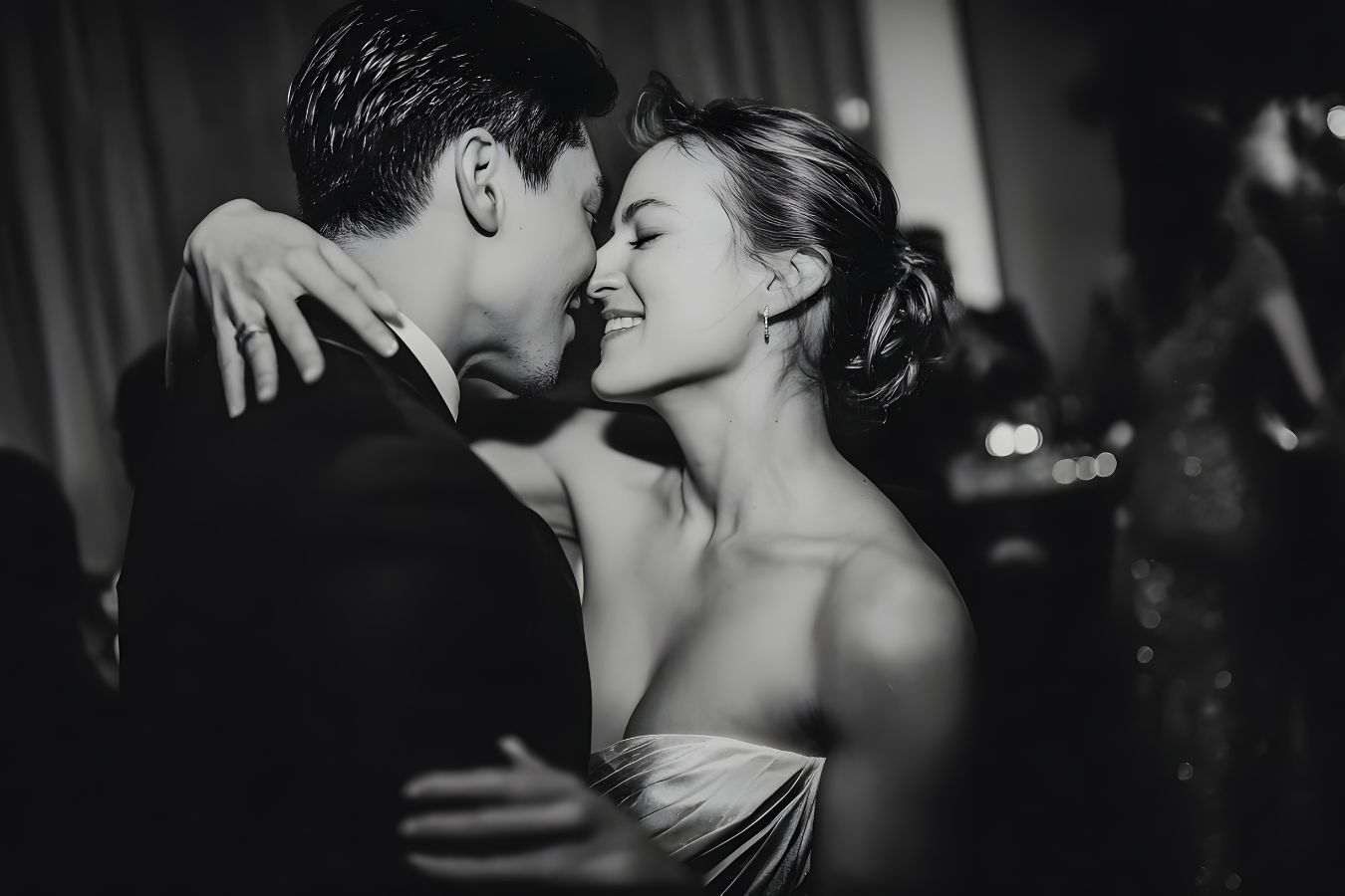 Wedding couple smiling while leaning in for a kiss on the dancefloor