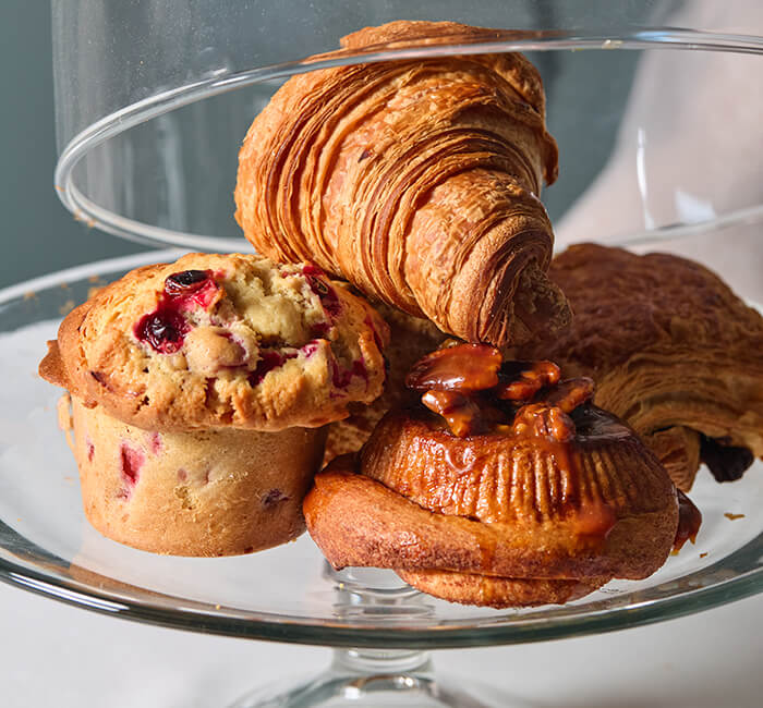 Pastries on a glass platter with a domed top