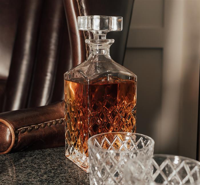 Whiskey on a side table next to a leather armchair