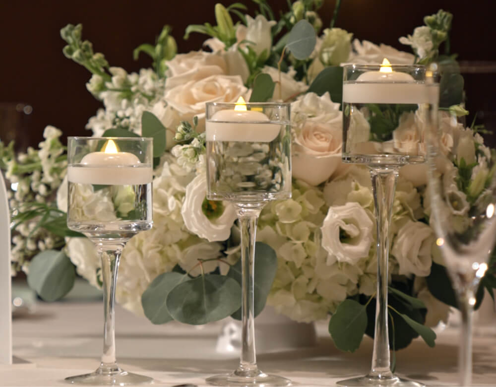 White floral centerpiece and glass floating candle holders