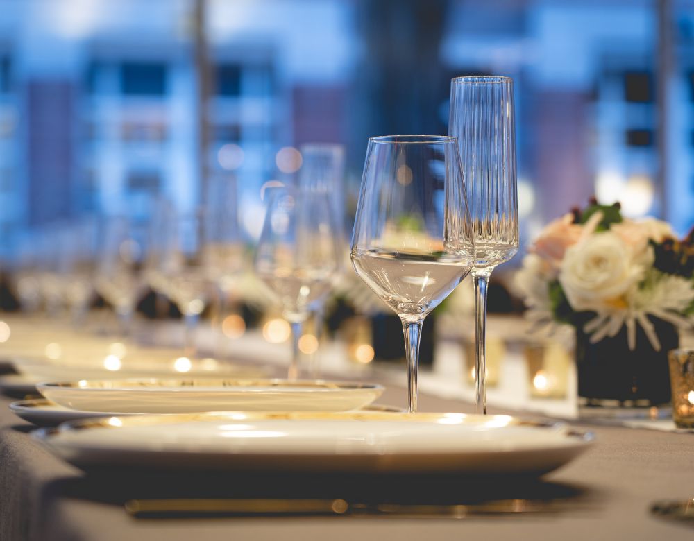 White floral arrangements, candles, and gold utensils