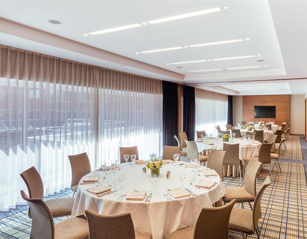 Rogers Stratton dining area with circular dining tables and a wall of windows with lots of natural light