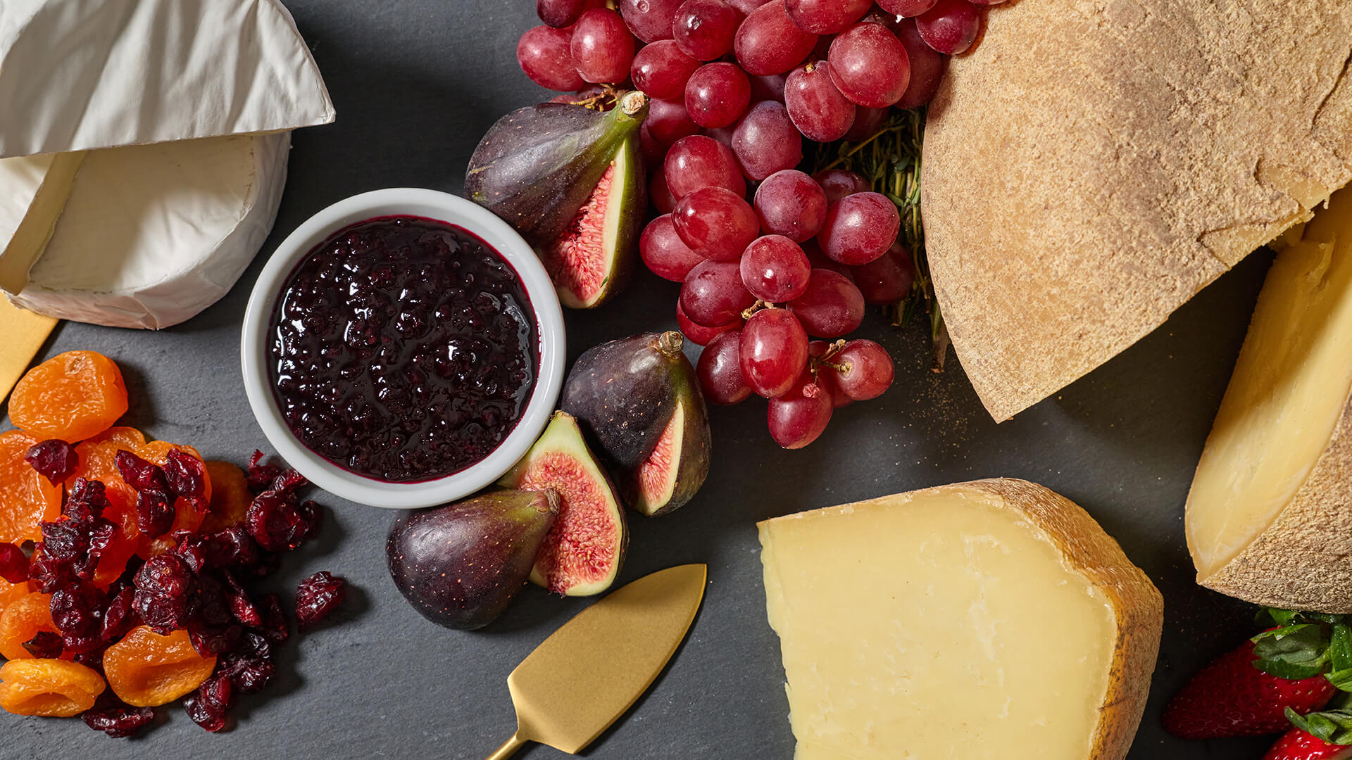 Fruit and cheese tray with a gold serving spatula
