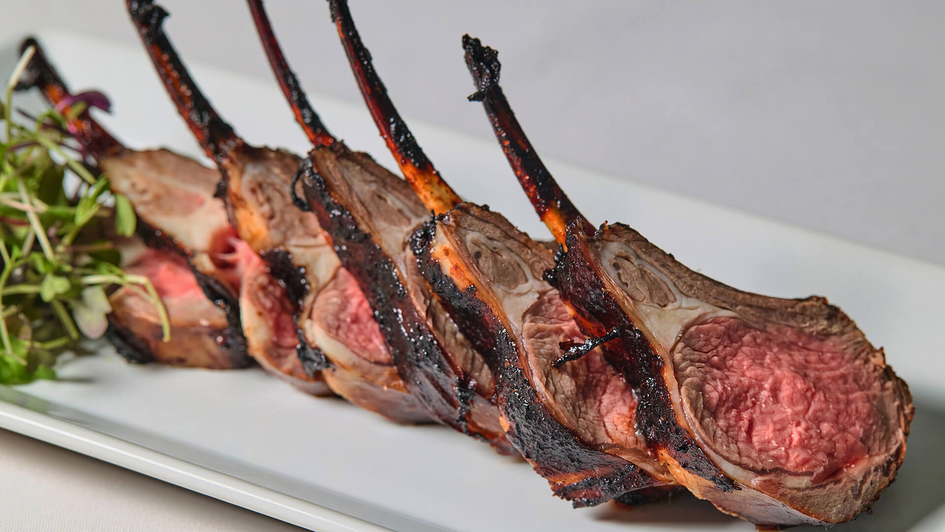 Rack of lamb cut into slices with fresh greens