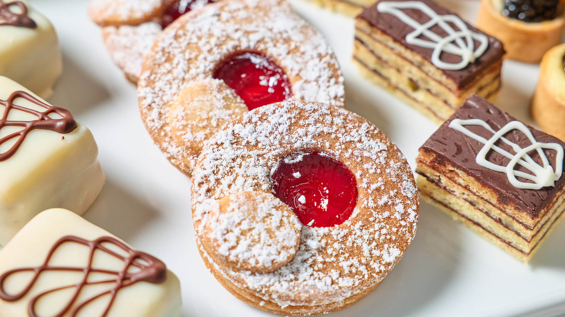 Dessert tray with an array of layered, chocolate covered, and jelly-filled desserts