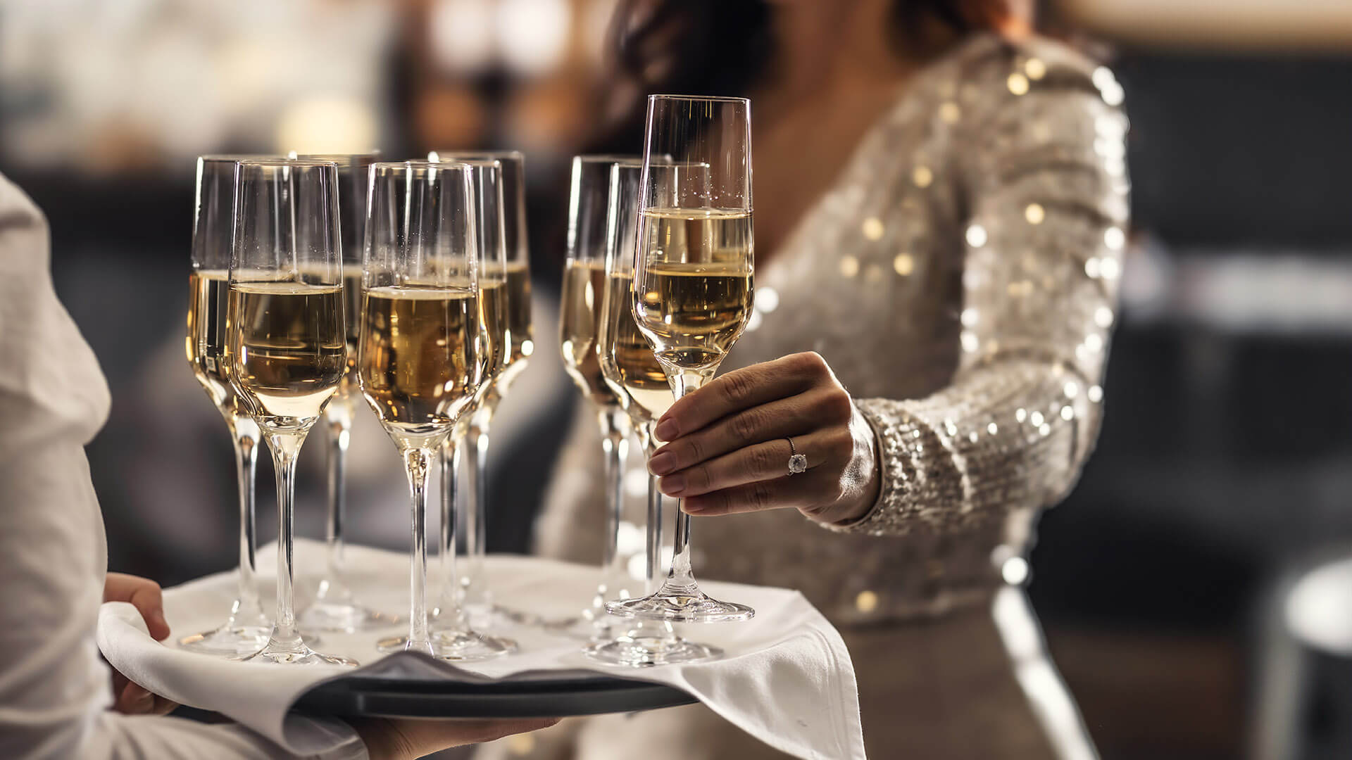 Bride grabbing champagne off of a tray