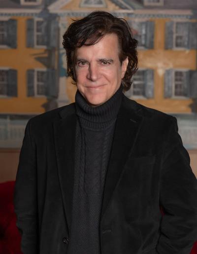 Michael Murray in a navy blue suit jacket, a white dress shirt, and a maroon tie