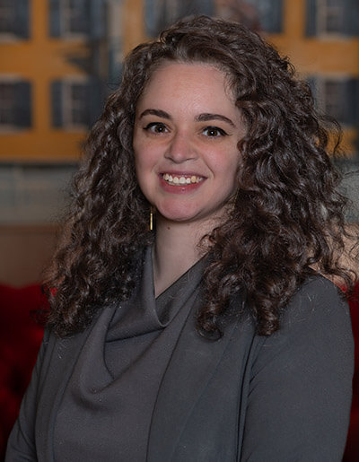 Melissa Rose in a grey dress with a cowl neck