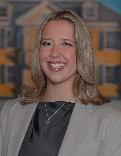 Olivia Michaud in a satin dark grey shift dress and a grey blazer