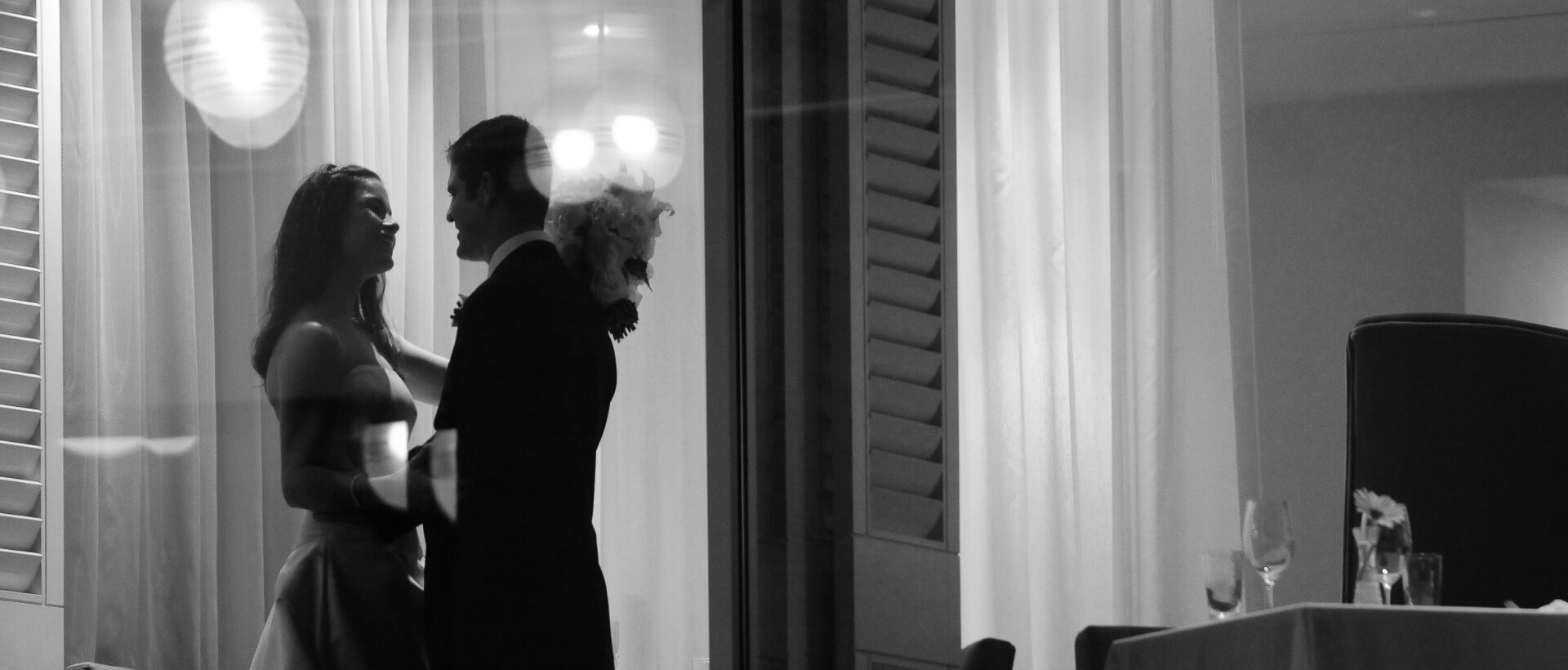 Couple looking into each others' eyes on a balcony